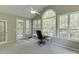 Bright sunroom with arched window and doors leading to deck, and view of the backyard at 1641 Rocky Knoll Ln, Dacula, GA 30019