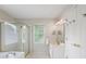 Bright bathroom featuring a glass shower, soaking tub, window, vanity, and modern fixtures at 2263 Seatton Ct, Marietta, GA 30062