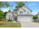 Inviting traditional two-story home featuring a well-maintained lawn, two-car garage, and a charming blue front door at 2263 Seatton Ct, Marietta, GA 30062