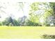Expansive grassy backyard with various trees, offering a private and serene outdoor space at 4045 Fawn Valley Dr, Loganville, GA 30052