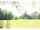 Large, grassy backyard area with a wooden playset visible, ideal for outdoor activities and enjoyment at 4045 Fawn Valley Dr, Loganville, GA 30052