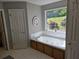 Bright bathroom showcasing a jetted tub with a view of the landscaped yard at 4045 Fawn Valley Dr, Loganville, GA 30052