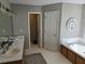 Well-lit bathroom featuring double sinks, a soaking tub, and tile flooring at 4045 Fawn Valley Dr, Loganville, GA 30052
