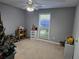 Neutral bedroom featuring a ceiling fan, a window, and gray-painted walls at 4045 Fawn Valley Dr, Loganville, GA 30052