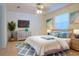 Charming bedroom featuring a ceiling fan, TV, decorative artwork and plenty of natural light at 1166 Memory Ln, Lawrenceville, GA 30044
