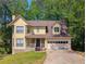 Charming two-story home with attached garage, stone accents, and mature trees at 1166 Memory Ln, Lawrenceville, GA 30044