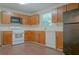Kitchen features wood cabinets, linoleum flooring, and white appliances at 1166 Memory Ln, Lawrenceville, GA 30044