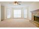 Living room with stone fireplace, ceiling fan, and carpeted floors at 1166 Memory Ln, Lawrenceville, GA 30044