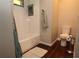 Bathroom features a tiled shower with black accents, toilet and wood flooring at 2218 Edgemore Se Dr, Atlanta, GA 30316
