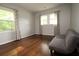 Bright bedroom with hardwood floors, gray walls, and gray futon couch at 2218 Edgemore Se Dr, Atlanta, GA 30316
