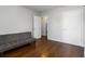 Bright bedroom with hardwood floors, gray walls, and gray futon couch at 2218 Edgemore Se Dr, Atlanta, GA 30316
