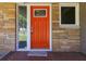 Close-up of an orange front door featuring sidelights and decorative hardware, creating an inviting entrance at 2218 Edgemore Se Dr, Atlanta, GA 30316