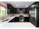 Well-equipped kitchen boasting quartz countertops, stainless steel appliances, and dark cabinetry for a sleek design at 2218 Edgemore Se Dr, Atlanta, GA 30316