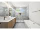 Modern bathroom with double vanity, soaking tub, frameless shower, marble-look tile, and stylish fixtures at 224 Cambridge Ave, Decatur, GA 30030