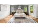 Bright bedroom features hardwood floors, a stylish rug, and a cozy bed with tufted headboard, and natural light at 224 Cambridge Ave, Decatur, GA 30030