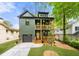Charming two-story home with olive green siding, a black roof, and double stacked, wood-railed front porches at 224 Cambridge Ave, Decatur, GA 30030