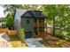 Olive-green home with a modern design, a well-manicured lawn and double stacked wood-railed porches at 224 Cambridge Ave, Decatur, GA 30030