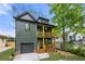 Two story home in olive green, with double stacked wood-railed front porches and a well-kept lawn at 224 Cambridge Ave, Decatur, GA 30030