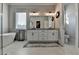 Bright bathroom with a soaking tub, toilet, double vanity, and large window at 86 Ewing Way, Dacula, GA 30019