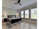 Tranquil bedroom featuring three windows with views, neutral décor, and a ceiling fan at 86 Ewing Way, Dacula, GA 30019