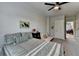 Bright bedroom with gray carpet and a ceiling fan, showcasing a bed and a view to a door at 86 Ewing Way, Dacula, GA 30019