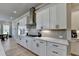 Close-up of a kitchen featuring white cabinets, gray backsplash, and stainless steel range hood at 86 Ewing Way, Dacula, GA 30019