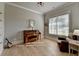 Cozy living room features hardwood floors, a window with natural light, piano, and a comfortable leather recliner at 86 Ewing Way, Dacula, GA 30019