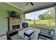 Covered patio featuring a brick fireplace, ceiling fan, tv and beautiful backyard views at 86 Ewing Way, Dacula, GA 30019