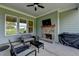 Covered patio featuring a brick fireplace, ceiling fan, tv and outdoor seating at 86 Ewing Way, Dacula, GA 30019