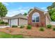 Charming brick home with a well-manicured lawn and a detached garage with flowers around at 2416 Centennial Hill Nw Way, Acworth, GA 30102