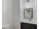 Contemporary powder room featuring wainscoting, modern vanity with a sink, and a designer mirror and lighting fixture at 2726 Talley Ln, Buford, GA 30519