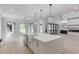 Modern kitchen with a central island, farmhouse sink, stainless appliances, and sleek white cabinetry at 2726 Talley Ln, Buford, GA 30519