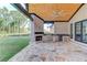 Expansive outdoor kitchen featuring stone floors, brick, wood ceilings, and stainless appliances, perfect for entertaining at 2726 Talley Ln, Buford, GA 30519