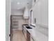 A walk-in pantry next to a modern kitchen with stainless steel appliances and custom shelving and cabinets at 2726 Talley Ln, Buford, GA 30519