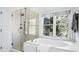 Modern bathroom featuring a glass shower, soaking tub, and a large window at 1048 Standard Ne Dr, Brookhaven, GA 30319