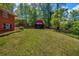 Manicured backyard with green grass and a charming barn style storage shed at 2396 Midvale Cir, Tucker, GA 30084