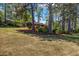 A neatly mowed front lawn reveals a glimpse of the house with mature trees at 2396 Midvale Cir, Tucker, GA 30084