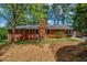Expansive backyard view of a brick home with a chimney and a well-maintained lawn at 2396 Midvale Cir, Tucker, GA 30084