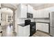 Contemporary kitchen with white cabinetry, black appliances and granite countertops at 4440 Spring Mtn Ln, Powder Springs, GA 30127