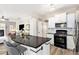 Modern kitchen features a black granite island and stainless steel appliances at 4440 Spring Mtn Ln, Powder Springs, GA 30127