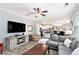 Open-concept living area with fireplace, large TV, and a view into the kitchen at 4440 Spring Mtn Ln, Powder Springs, GA 30127