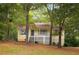 Charming yellow home with a cozy front porch and lush green trees surrounding the property at 21 Misty Hollow Ct, Euharlee, GA 30145