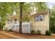 Inviting yellow home featuring a quaint front porch, side stairs and complemented by natural surroundings at 21 Misty Hollow Ct, Euharlee, GA 30145