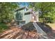 Exterior view of green home with landscaped yard and stone walkway surrounded by mature trees at 225 Bayswater Dr, Suwanee, GA 30024