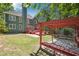 Large green backyard featuring a red deck, a pergola, and a well-maintained lawn at 225 Bayswater Dr, Suwanee, GA 30024