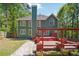 Green home with a red deck, a pergola, and a spacious yard with manicured lawn at 225 Bayswater Dr, Suwanee, GA 30024