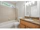 Cozy bathroom featuring a bathtub, granite countertop vanity, and decorative mirror at 225 Bayswater Dr, Suwanee, GA 30024