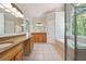 Bright bathroom featuring double vanity with granite counters, soaking tub, and glass enclosed shower at 225 Bayswater Dr, Suwanee, GA 30024