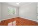 Bright bedroom featuring a ceiling fan, hardwood floors, and natural light from the window at 225 Bayswater Dr, Suwanee, GA 30024
