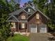 Traditional brick home featuring an attached two-car garage and professionally landscaped front yard at 225 Bayswater Dr, Suwanee, GA 30024